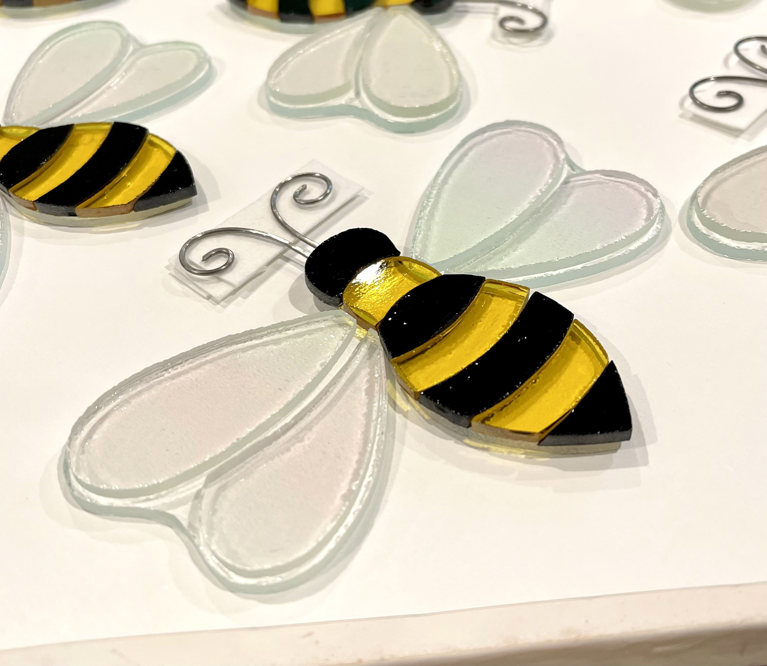 Fused glass bee pieces stacked on a kiln shelf ready for firing